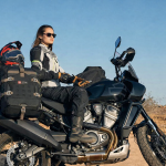 Female rider with premium motorcycle touring gear and adventure bike.