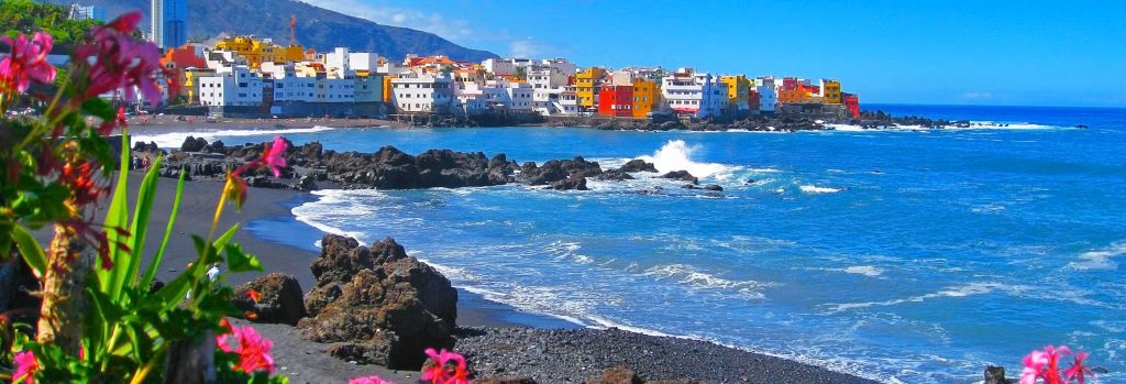 Colorful coastal town and beach in Tenerife North during a holiday package trip